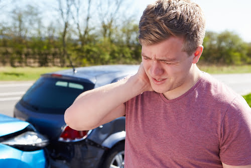 man touching his neck due to car accident